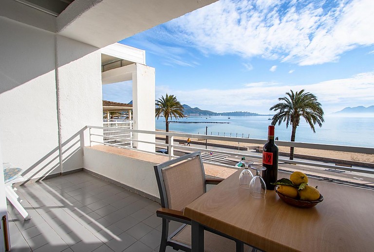 Balkon des Apartments mit Esstisch und Blick auf das Meer