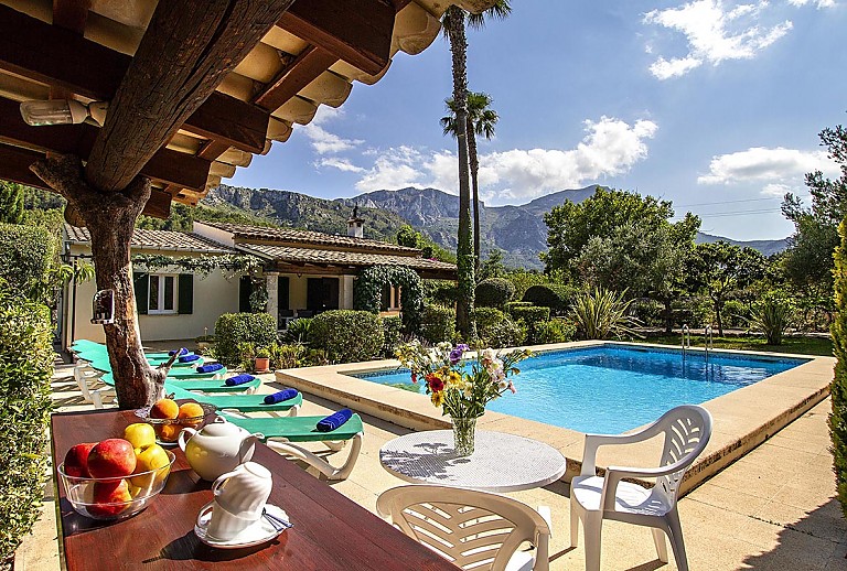 Terrasse mit Esstisch Stühlen und Grill am Pool