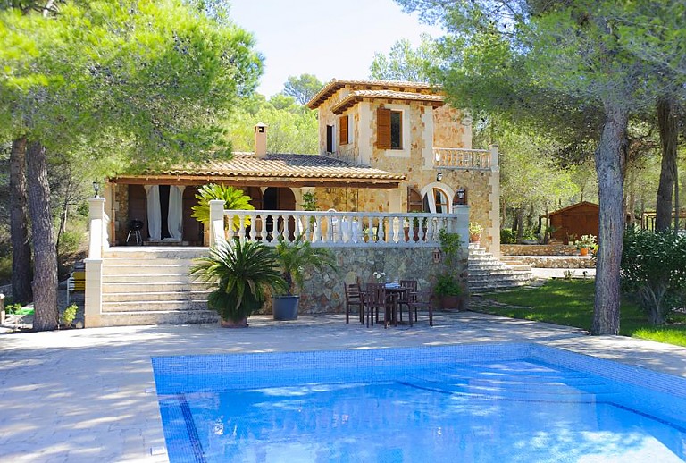 Pool mit Sonnenliegen und Bäumen vor der Finca