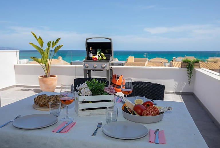 Grill und gedeckter Tisch auf der Terrasse