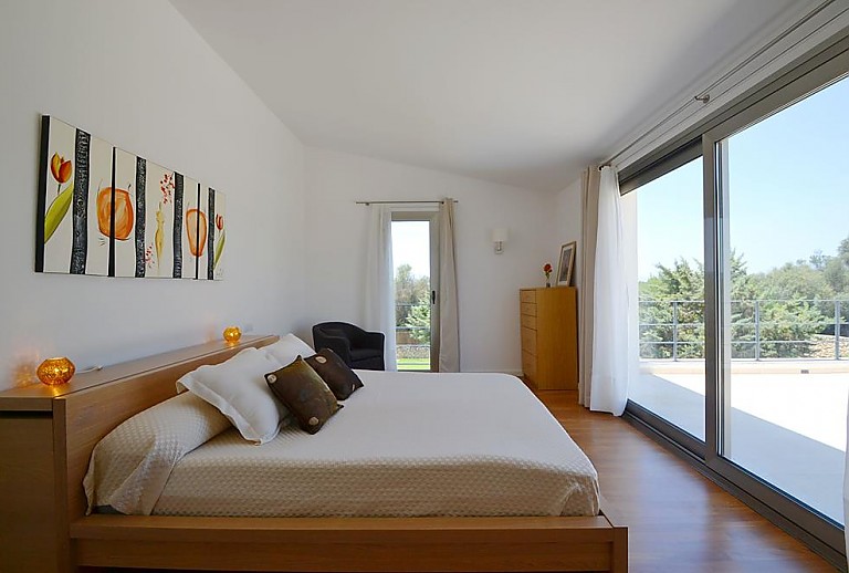 Doppelbett im Schlafzimmer mit Terrasse