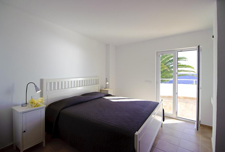 Schlafzimmer mit Doppelbett und Balkontür
