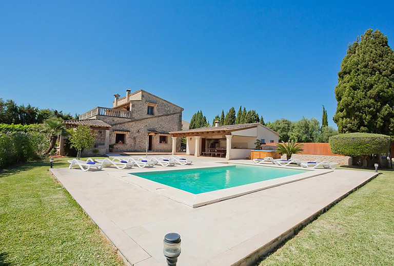 Poolterrasse mit Sonnenliegen und Essbereich vor der Finca