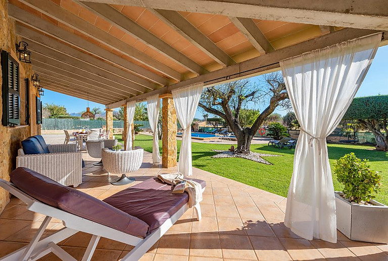 Terrasse mit Gartenmöbeln und Poolblick